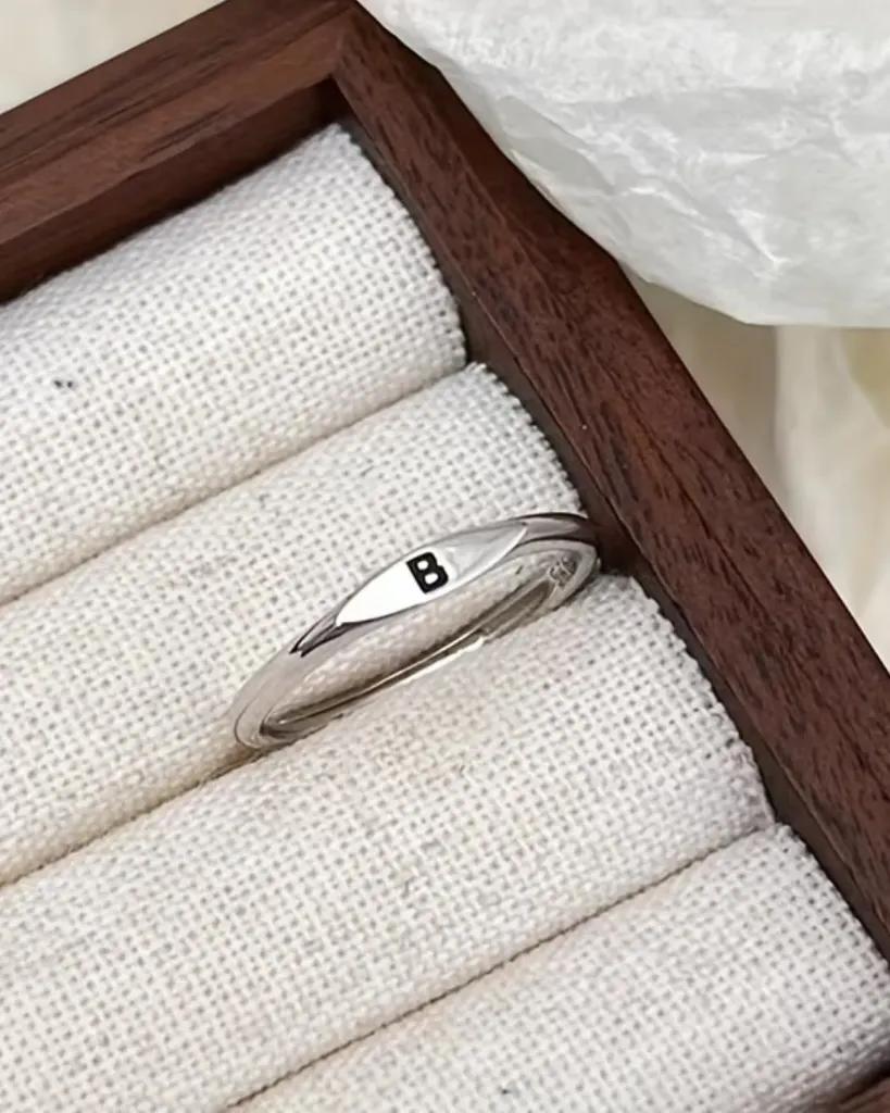 Narrow marquise-faced signet ring in rhodium-plated brass with an engraved initial