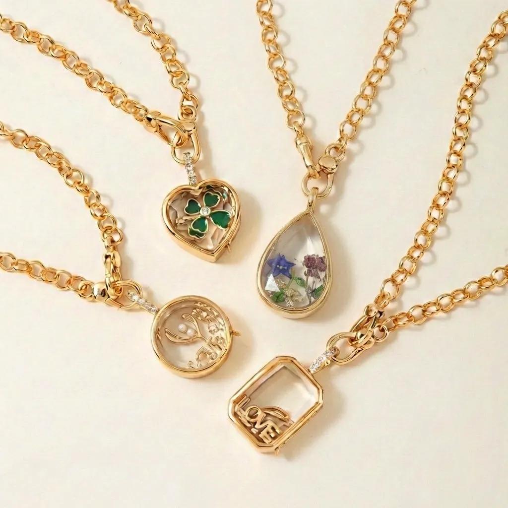 Four floating locket pendant shapes in gold tone, each with a clear glass front on a rolo chain