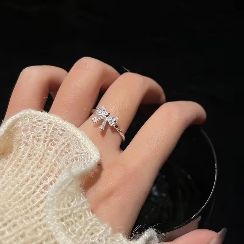Rhodium-plated ring with a rope-twisted band and a small cubic zirconia bow on top