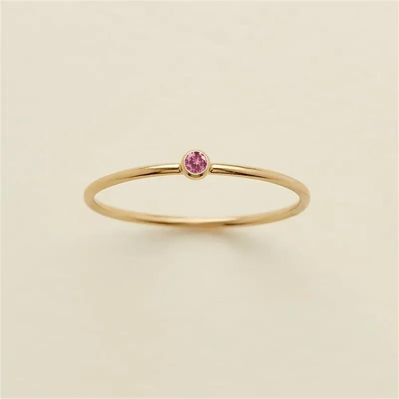 Small pink cubic zirconia bezel-set flush into a hair-fine gold-plated thread ring