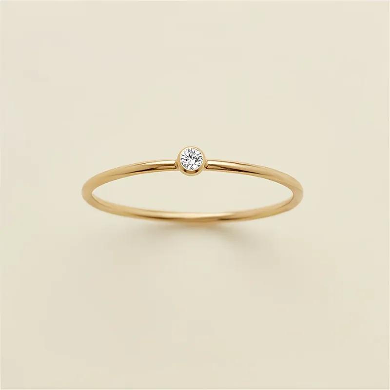 Clear cubic zirconia bezel-set into a hair-fine gold-plated thread ring