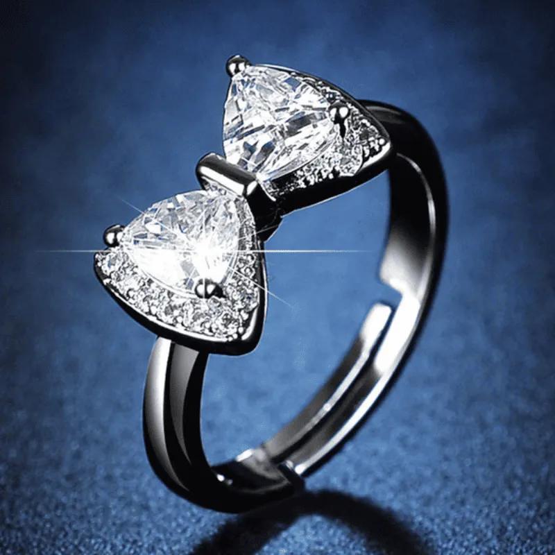 Two trillion-cut stones set base to base as a bow, with pave along the ring shoulders