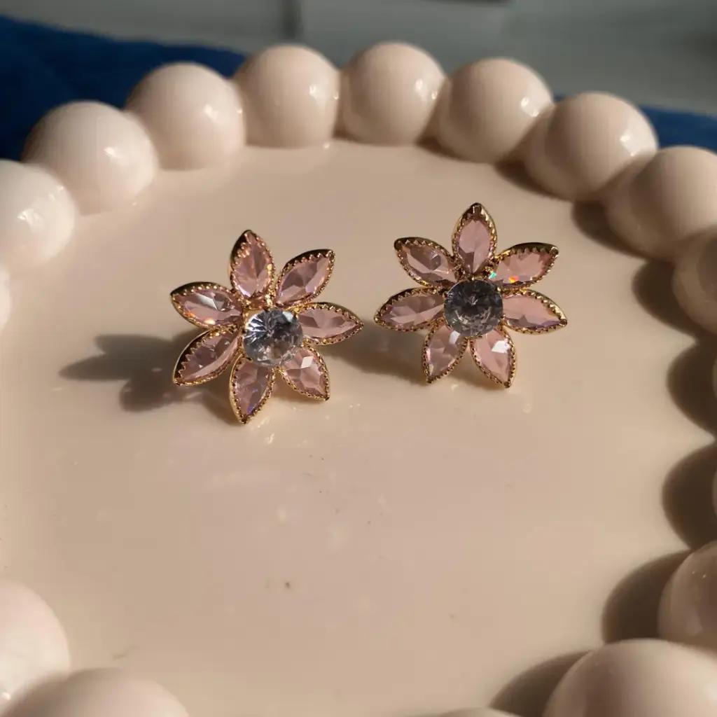 Six pale pink marquise stones set as petals around a clear round centre in gold-tone settings