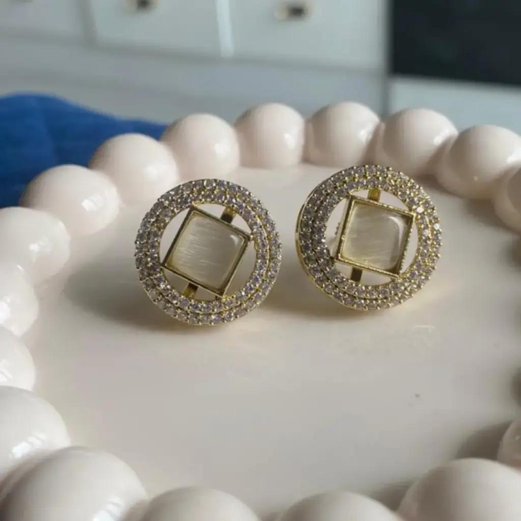 Milky square centre stone ringed by two rows of small cubic zirconia in a gold-plated stud