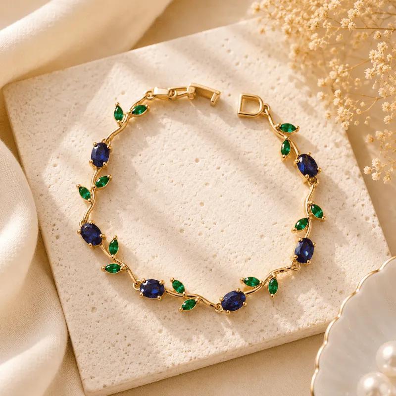 Blue oval stones with green marquises angled between them on a waved gold-tone chain