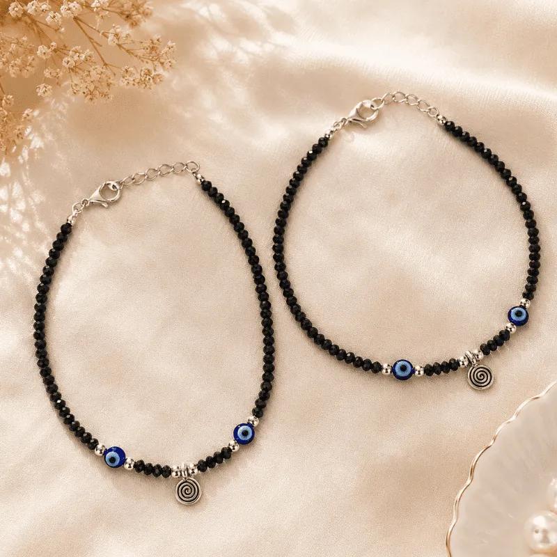 Strand of faceted black glass beads with blue and white nazar beads and a silver-tone spiral charm