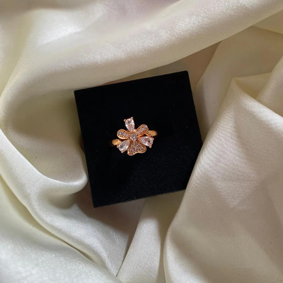 Rose gold-plated flower ring with five pear-cut cubic zirconia petals around a round centre stone, on a black display box