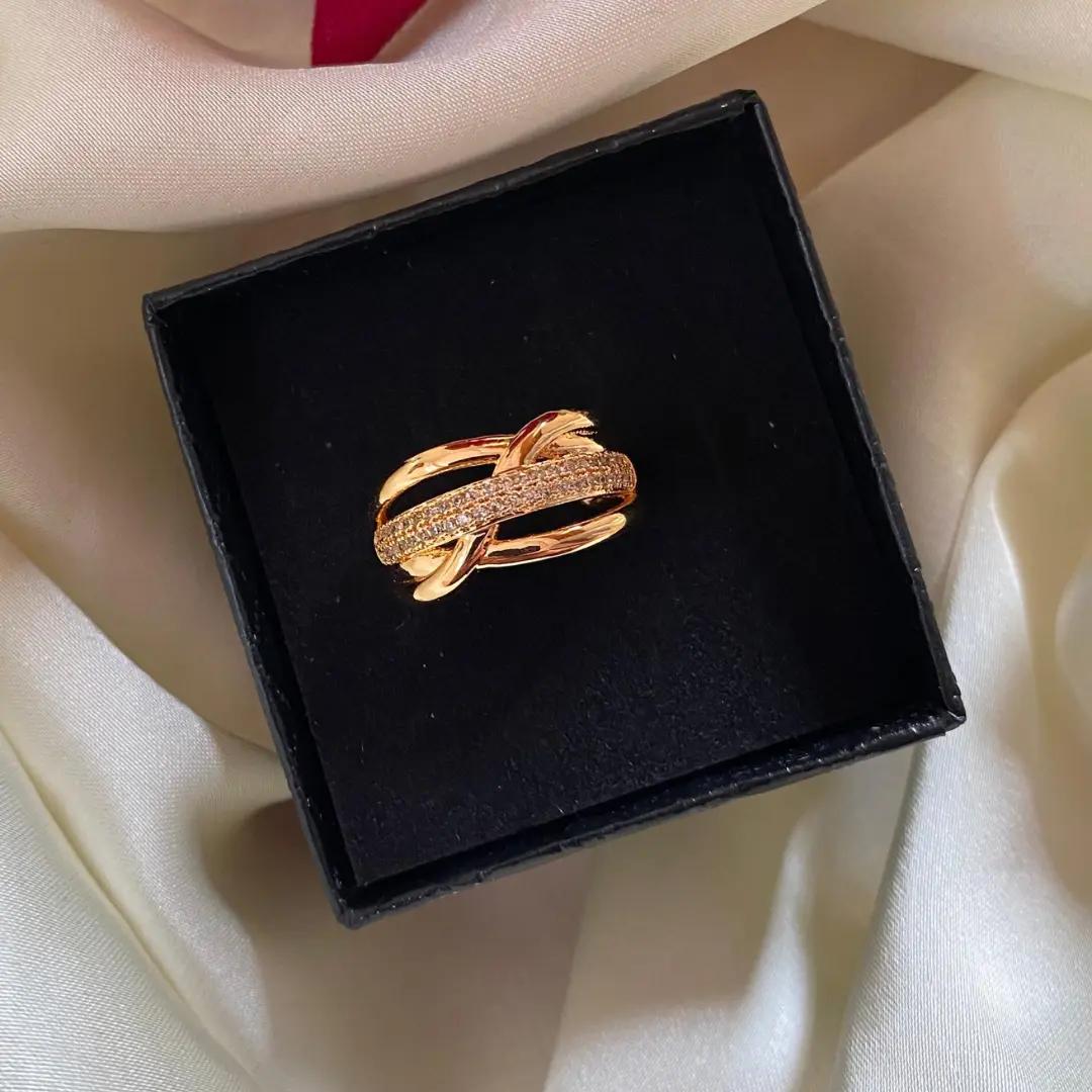 Wide interlaced crossover ring of three rose gold-plated strands with a central pavé cubic zirconia line