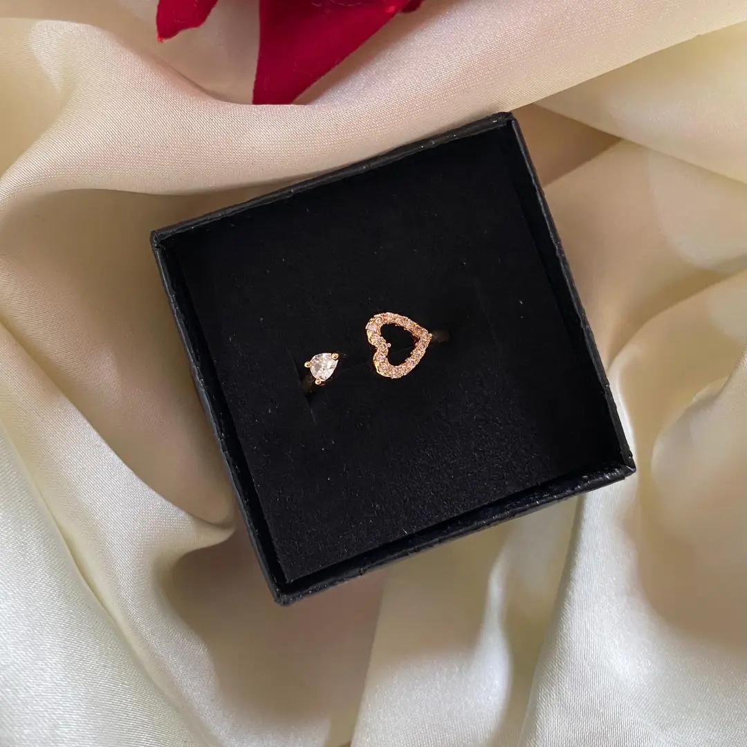 Adjustable open ring with an outlined cubic zirconia heart and a single teardrop stone in rose gold plating