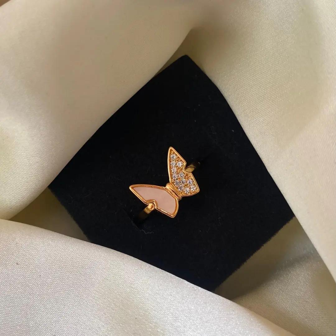 Perched butterfly ring with one pavé cubic zirconia wing and one pale pink shell-look wing in rose gold plating