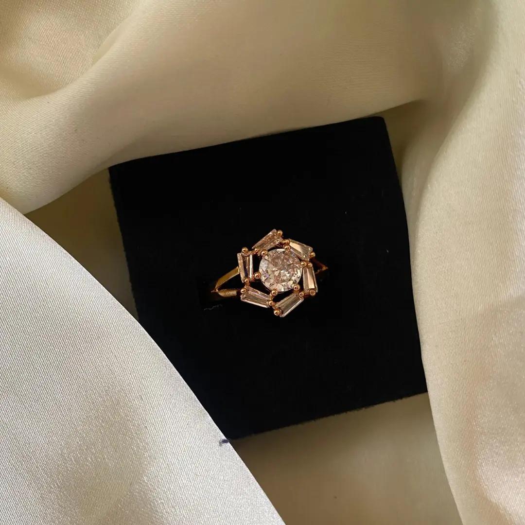 Rose gold-plated cluster ring with baguette cubic zirconia stones around a round centre stone