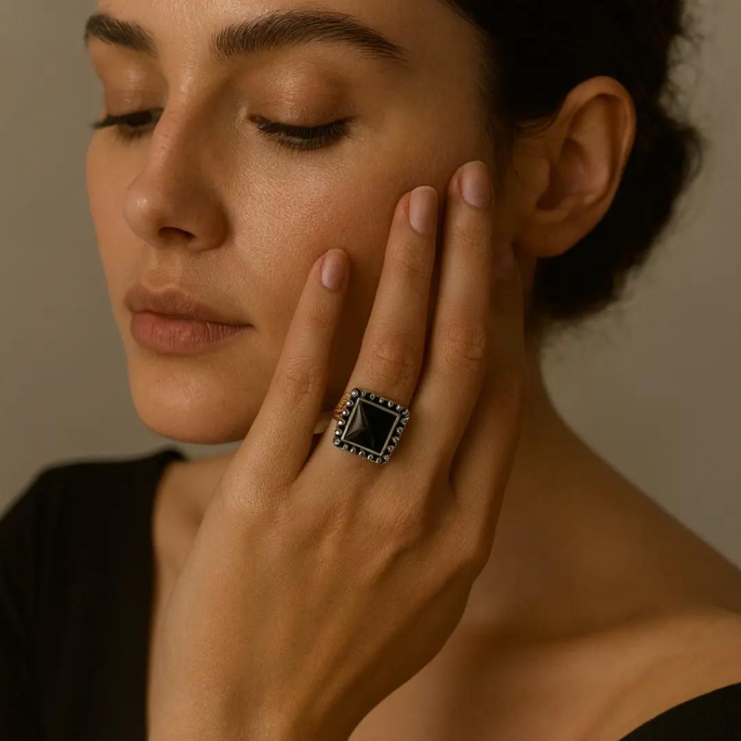 Two-tone ring with a faceted square black stone in a beaded silver-finish frame