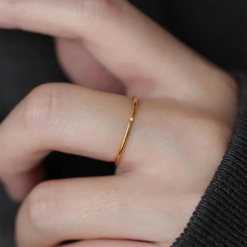 Slim gold-finish ring with a row of tiny clear stones along a thin band