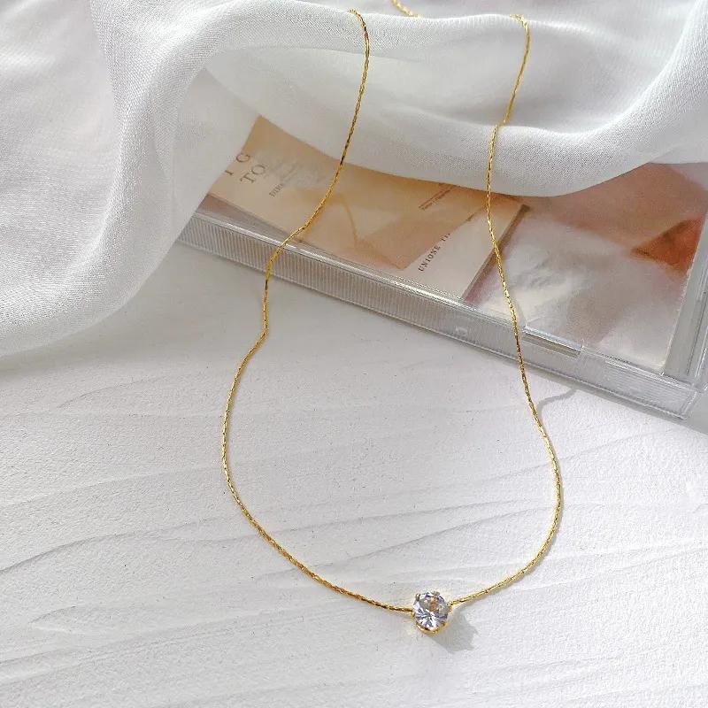 Gold-tone chain necklace with a single clear-stone solitaire pendant