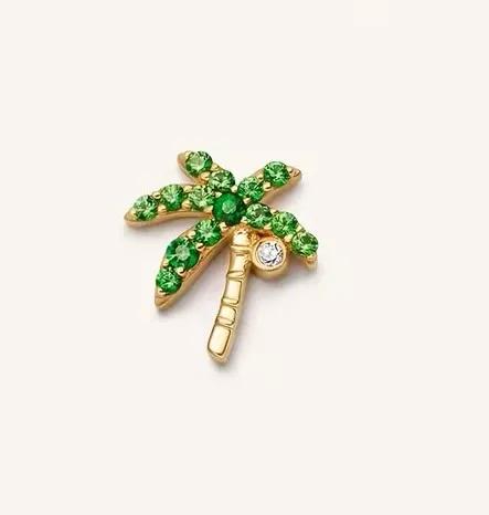 Gold-tone coconut palm charm with green stone fronds, a ridged trunk and one clear stone at the crown