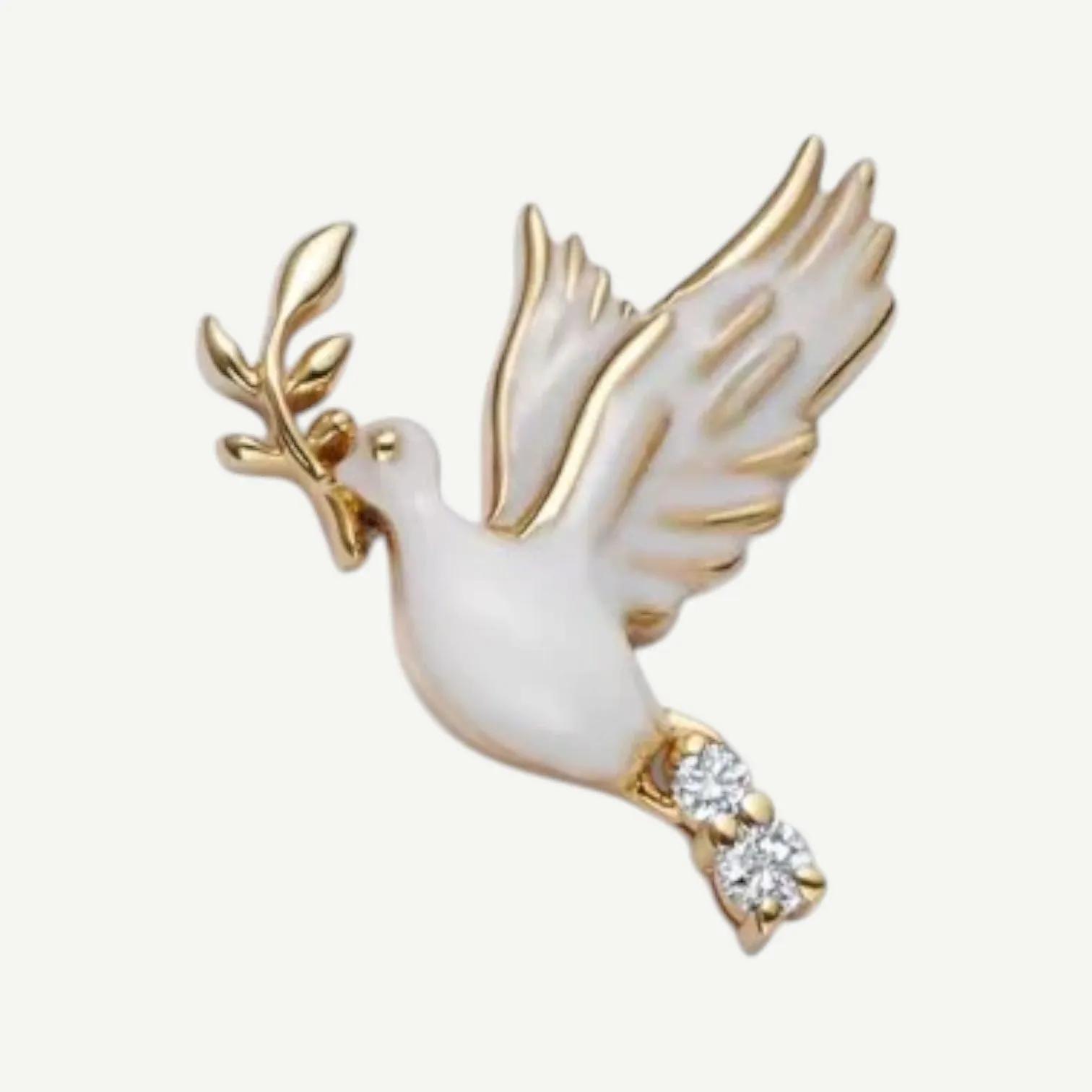 White and gold-tone dove charm in flight holding a golden olive branch, with two clear stones at its tail
