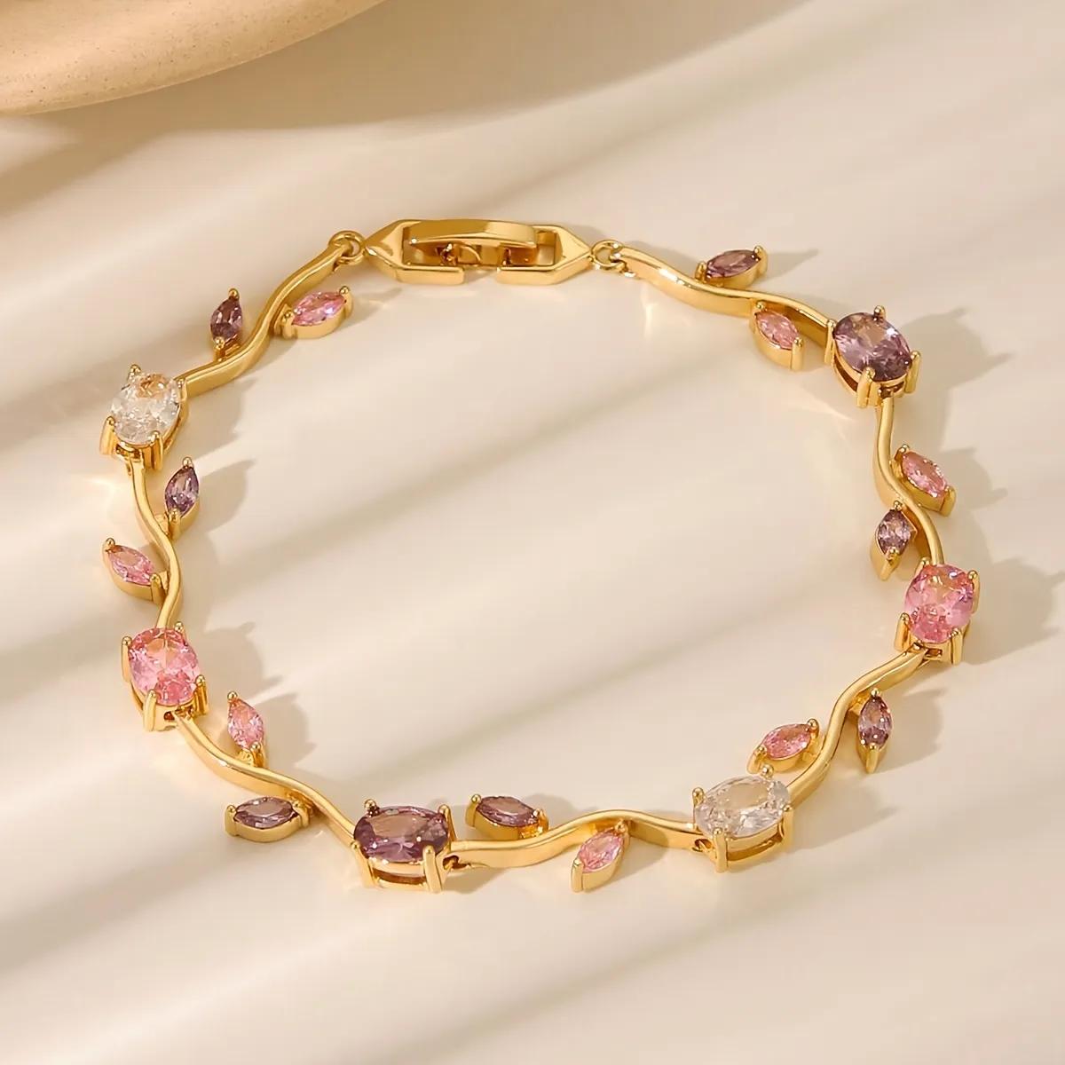 Gold-tone vine bracelet with prong-set pink, mauve and clear oval stones curved into a circle on satin