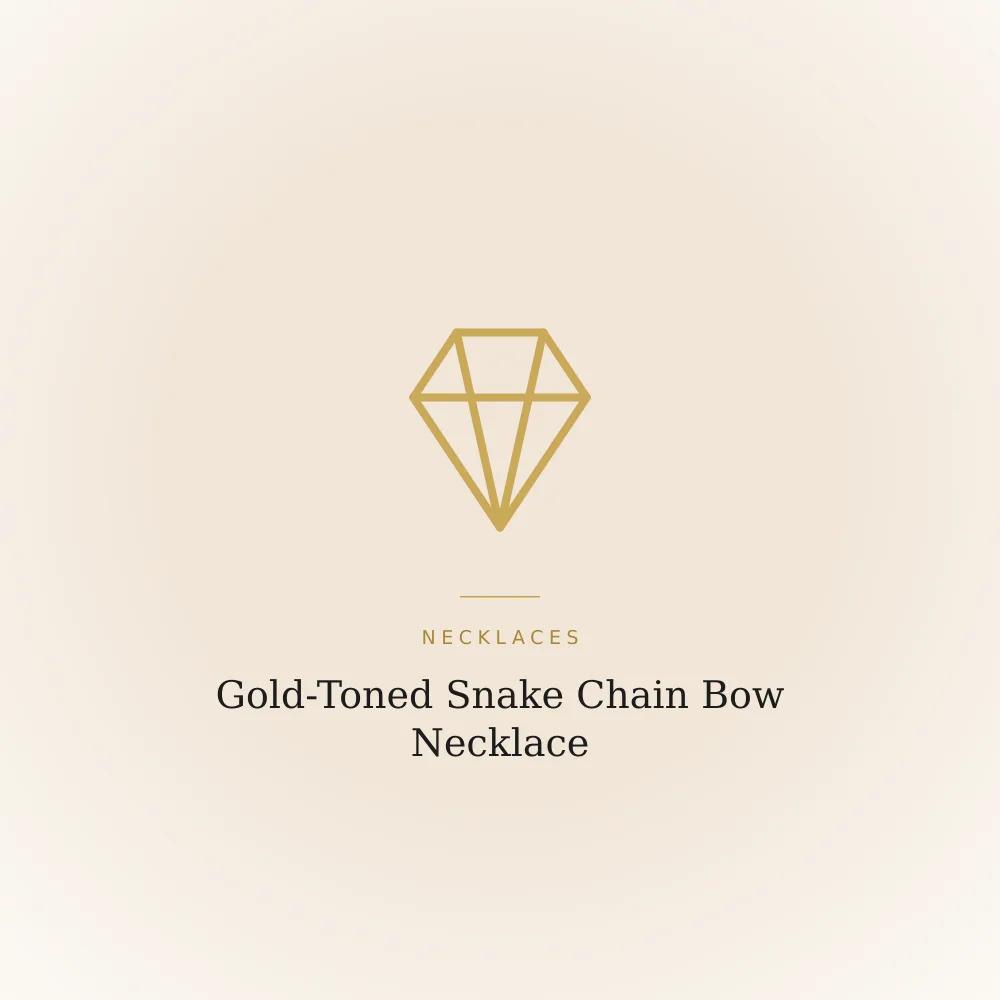 Sleek gold-toned snake chain necklace with a small ribbon bow pendant