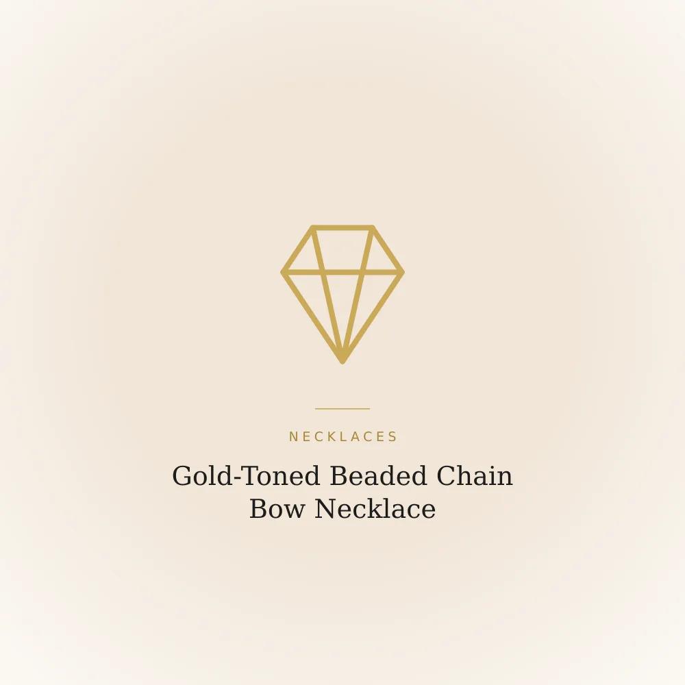 Gold-toned beaded chain necklace with a sculpted ribbon bow pendant