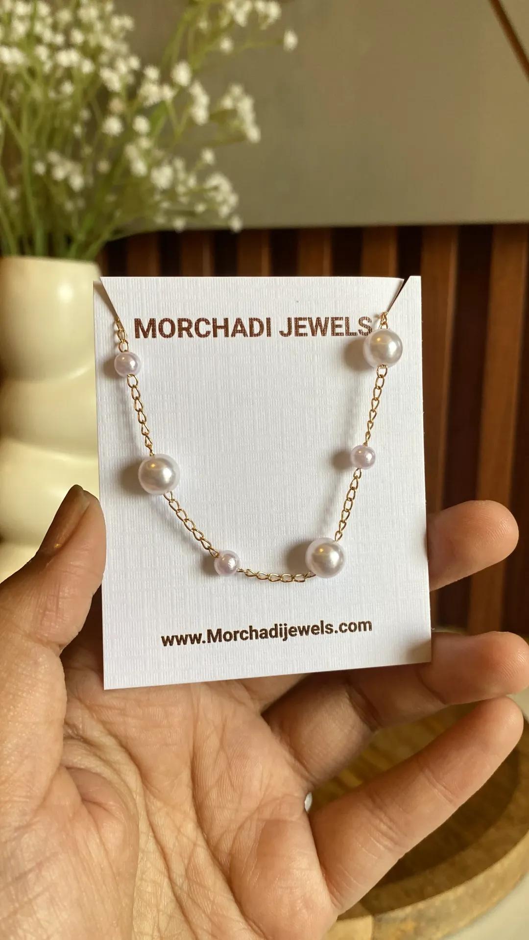 Gold-toned chain necklace with faux pearls spaced evenly along its length