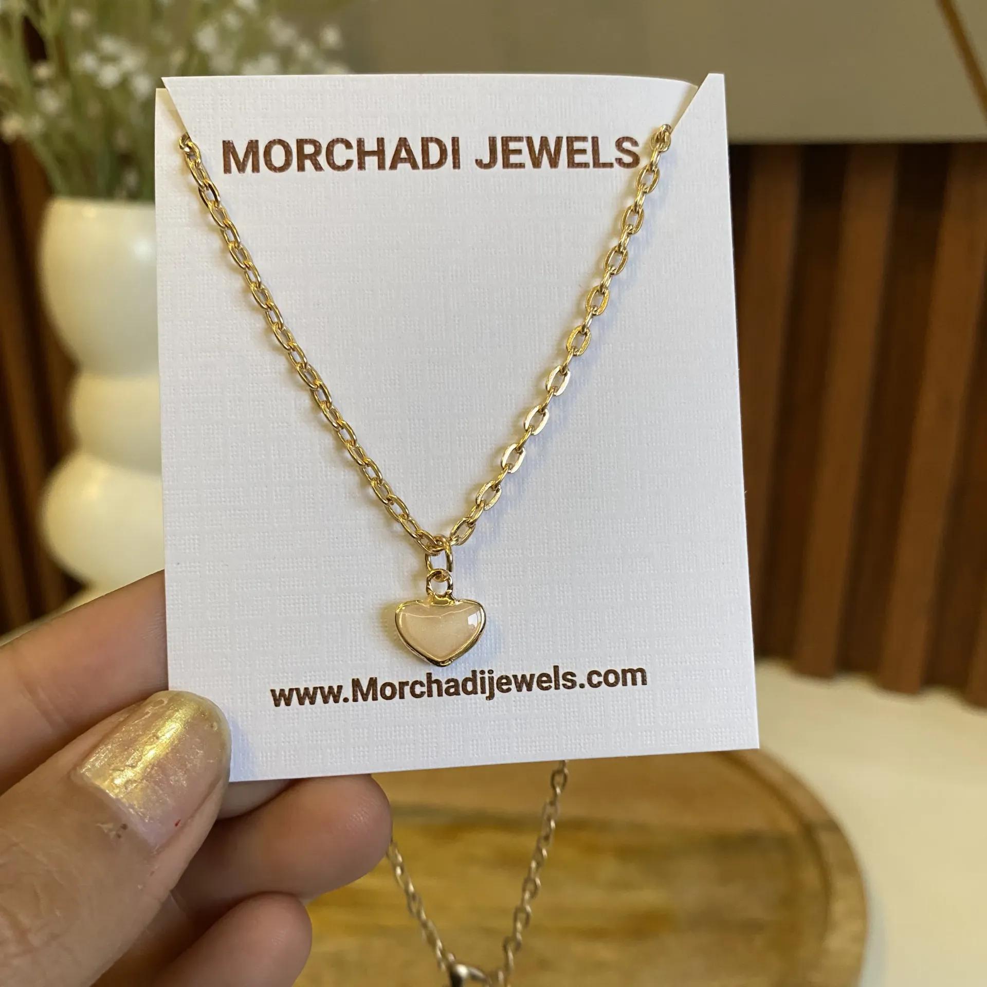 Gold-toned link chain necklace with a heart-shaped pendant and pearl-look centre
