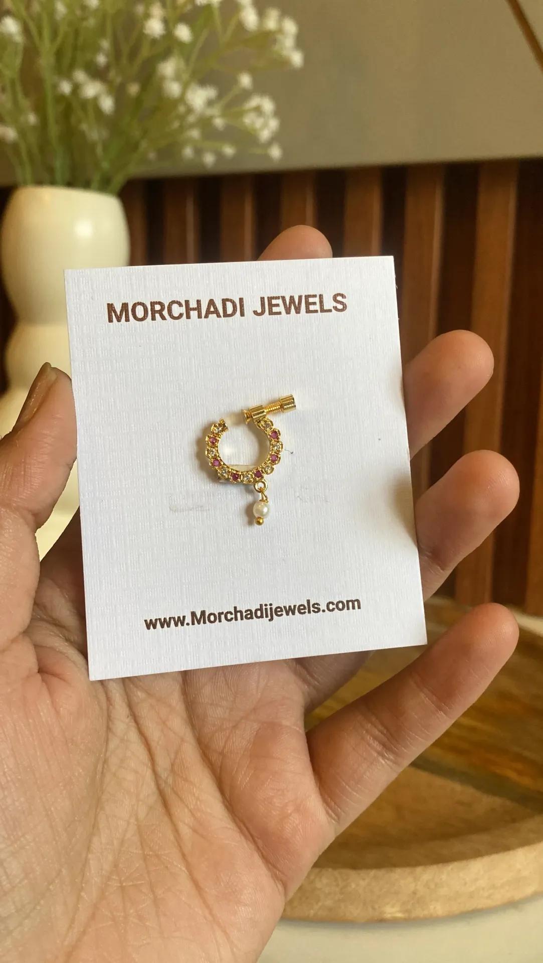 Gold-toned screw-fit nath with alternating ruby-red and clear stones and a pearl-look drop