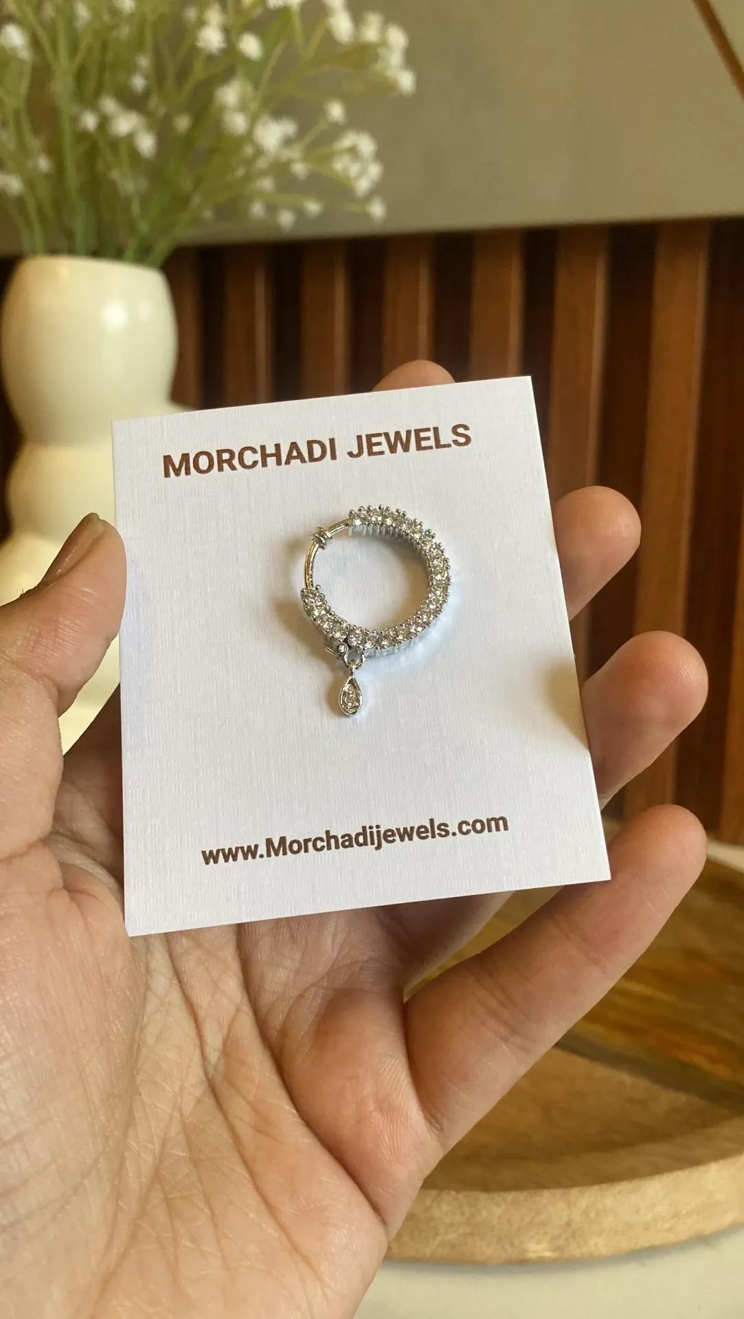Silver-toned nath with two rows of clear stones set close together and a teardrop drop