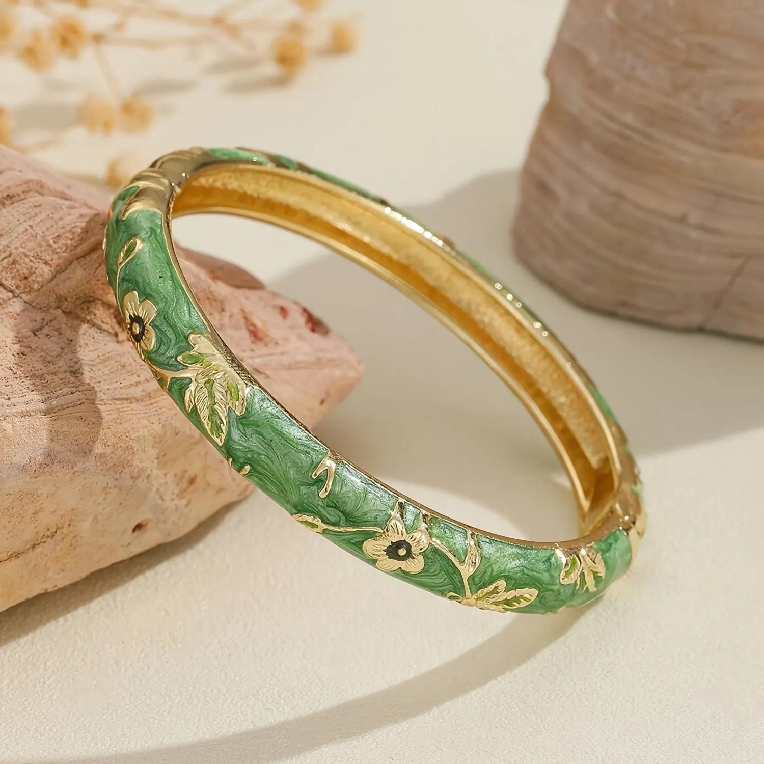 Green marbled enamel kada with gold-toned floral vine engraving and a hinged opening