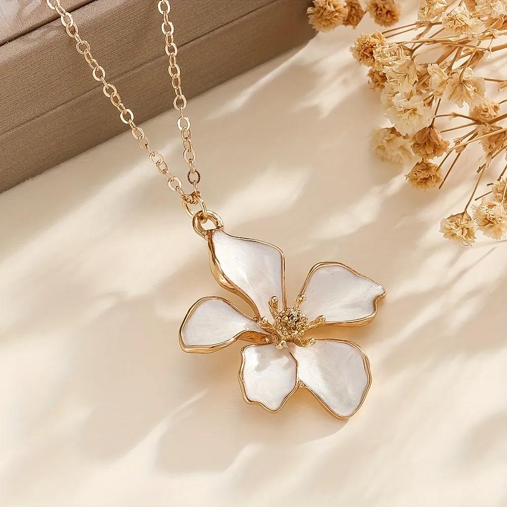 Gold-toned necklace with an irregular white enamel magnolia flower pendant