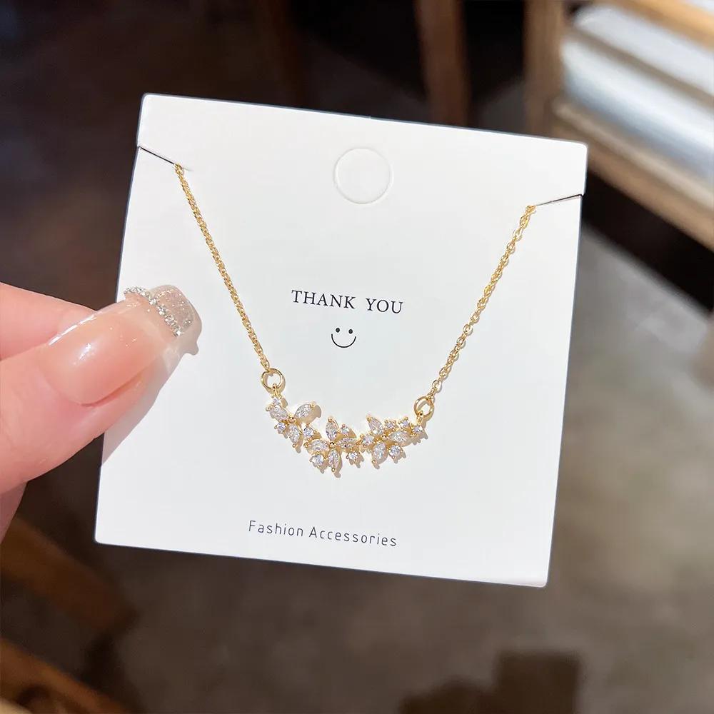 Gold-toned necklace with a cluster of clear marquise and round stones set along the chain