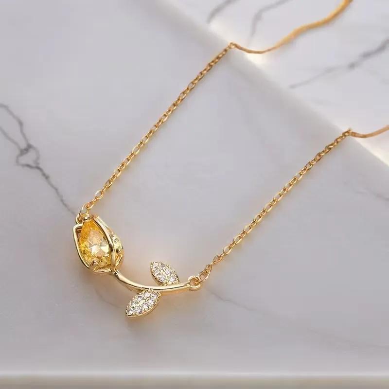 Gold-finished cable chain necklace with a yellow cubic zirconia tulip pendant and pave leaf stones