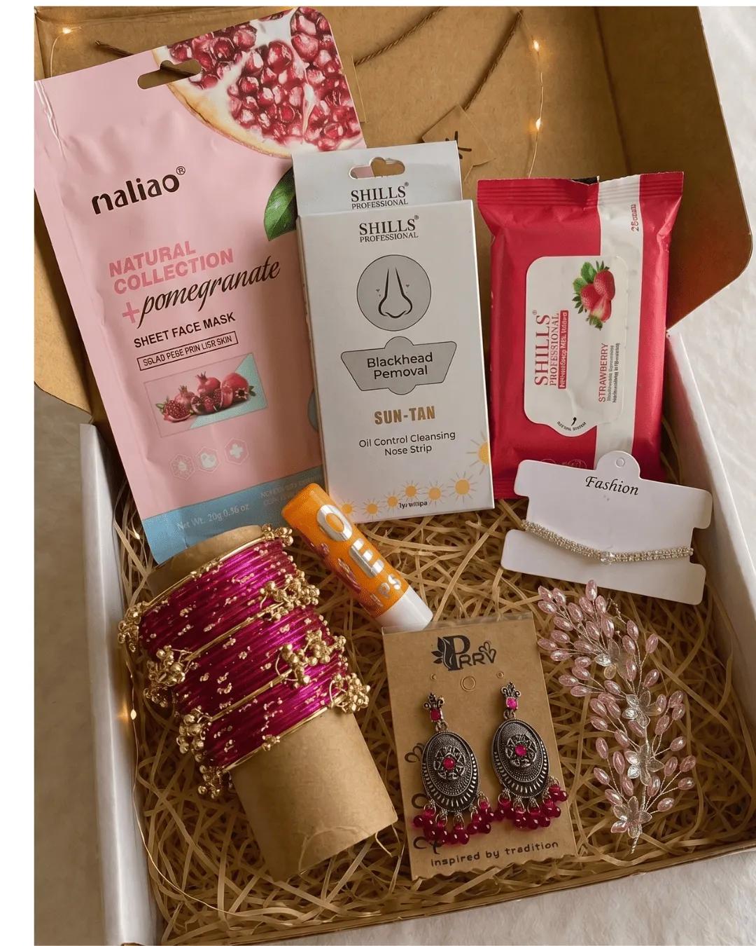 Open birthday hamper with sheet mask, nose strips, wipes, lip balm, pink bangles, jhumka earrings and a crystal hair pin