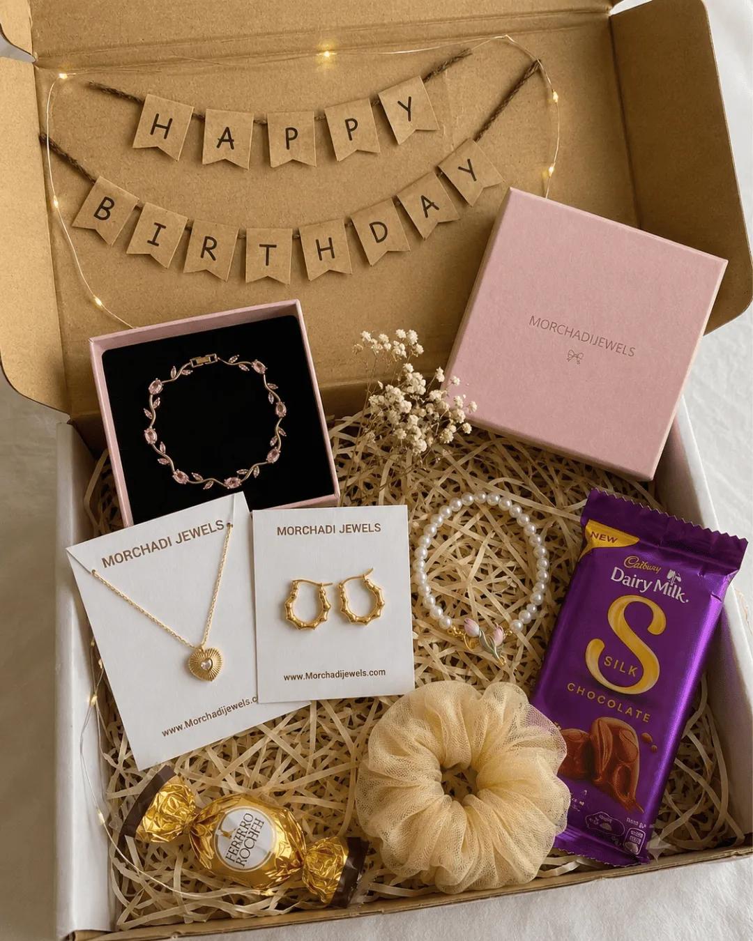 Luxury birthday hamper open to show a bracelet, pendant necklace, gold hoops and a pearl bracelet