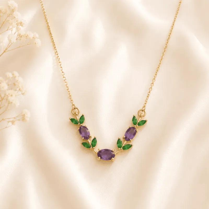 Gold-plated V-shaped vine necklace with deep purple cubic zirconia stones and emerald-green leaf accents