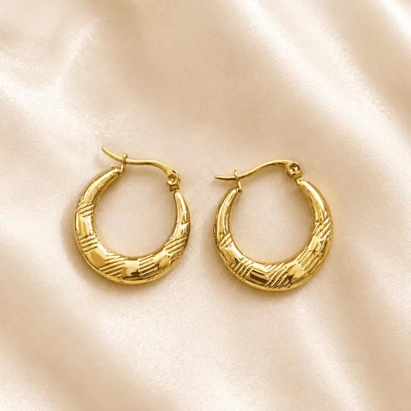 Oversized chunky gold-plated steel crescent hoop earrings with a concentric spiral texture