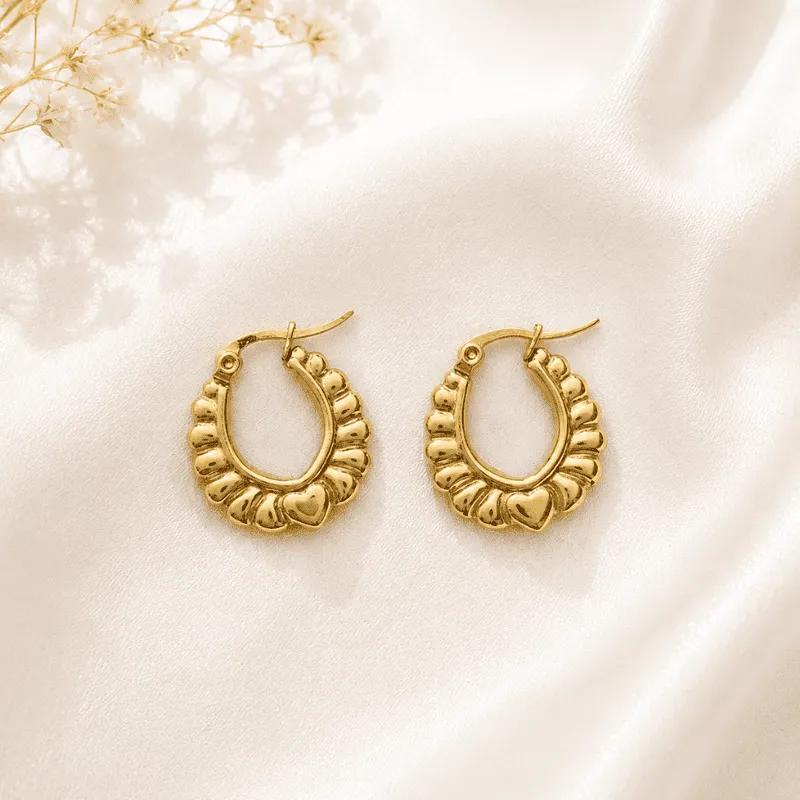 Medium gold-plated steel hoop earrings with an engraved diagonal crosshatch pattern