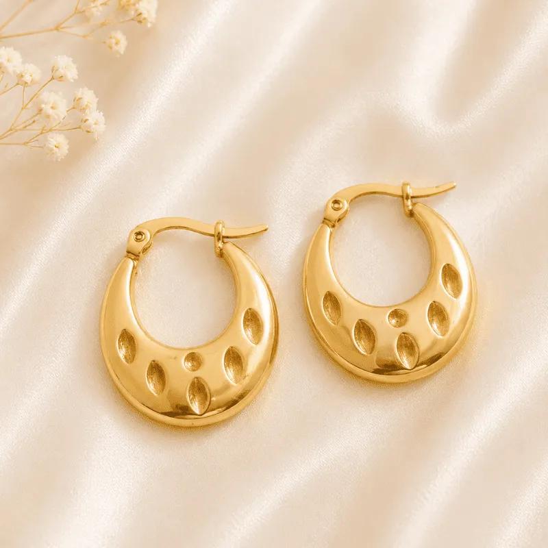 Gold-plated steel teardrop hoop earrings with oval cutouts forming a crescent-moon shape