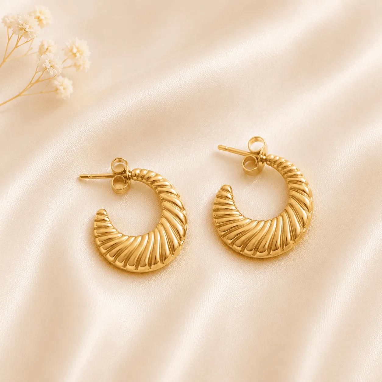 Gold-plated steel open C-hoop earrings with raised diagonal croissant-style ribbing