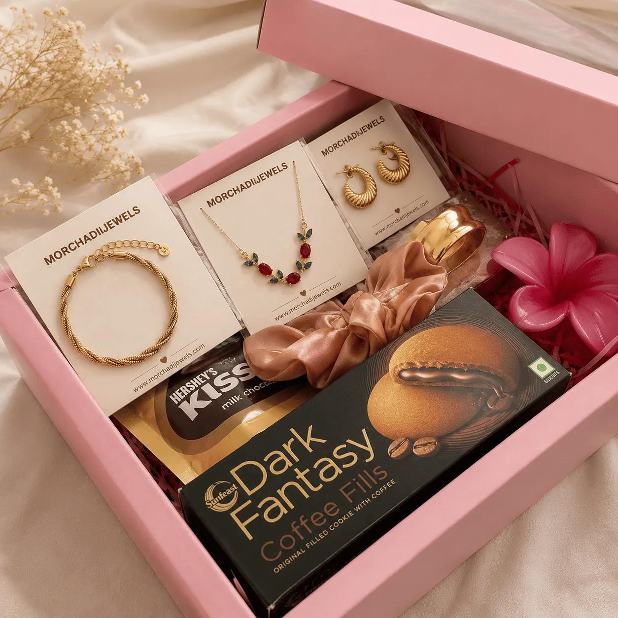 Pink gift box hamper with a gold-tone bracelet, a coloured-stone necklace and chocolates