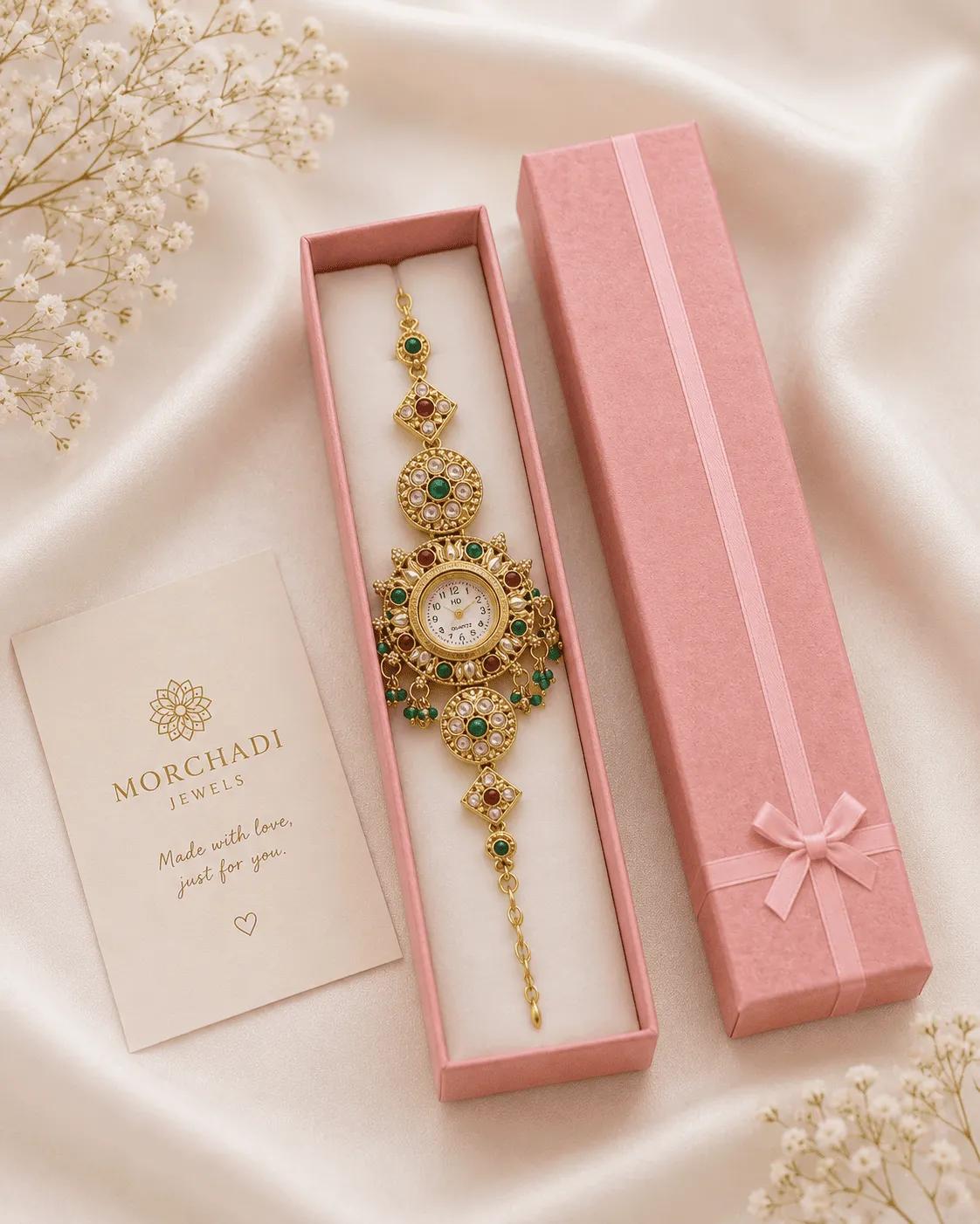 Antique gold-tone bracelet watch with kundan-style red and green stones and hanging beads