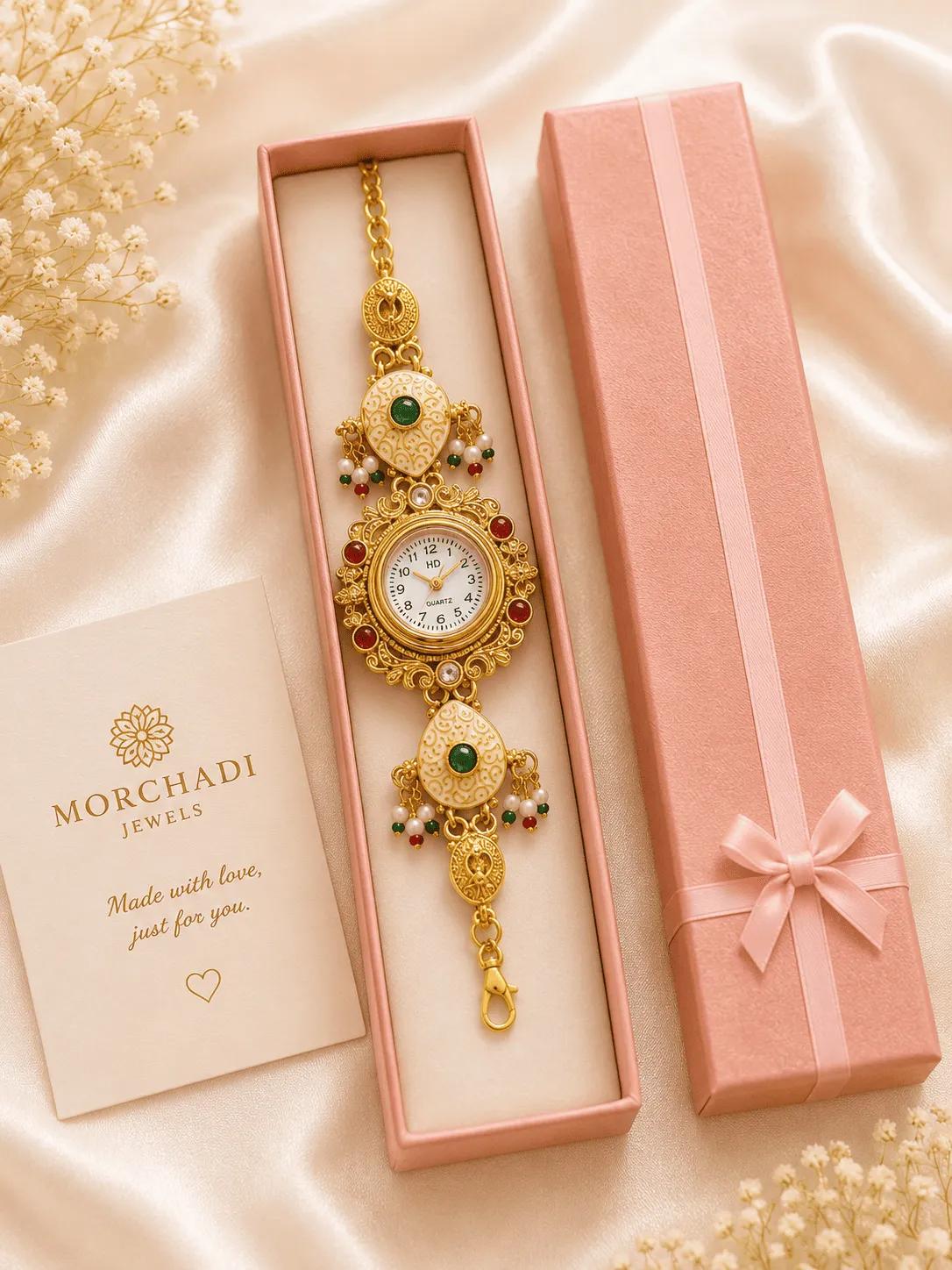 Antique gold-finish bracelet watch with ivory meenakari teardrops, green stones and pearl-look bead drops in a gift box