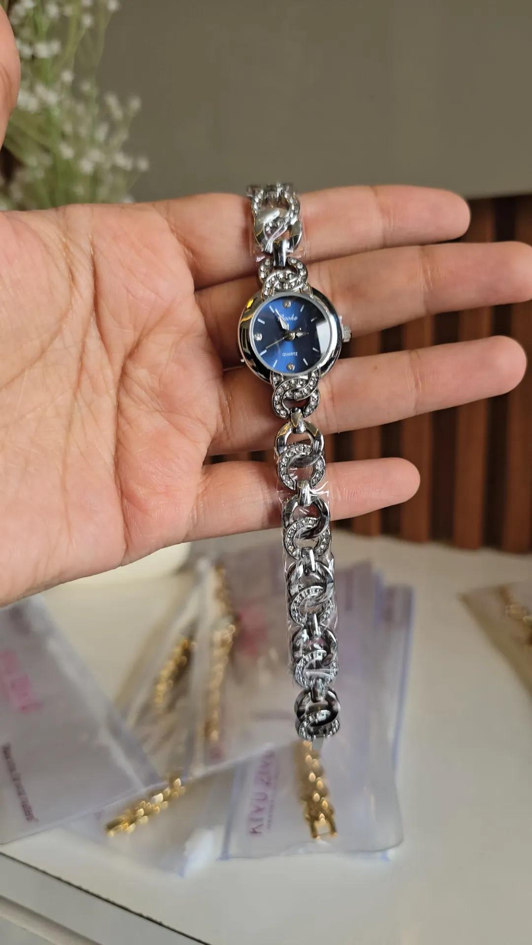 Silver-tone chain-link bracelet watch with a deep blue round dial and stone-set links