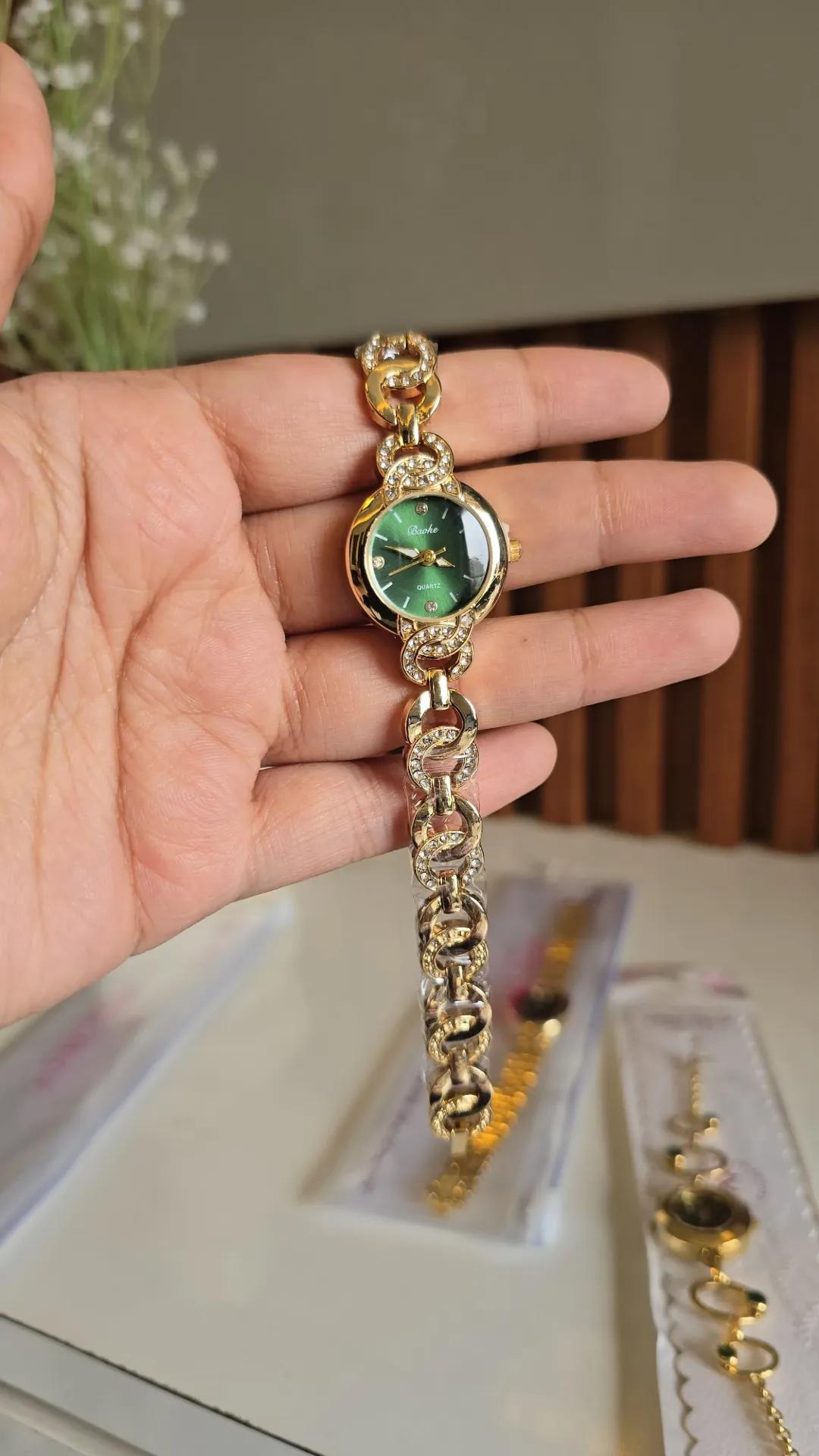 Gold-tone interlocking chain bracelet watch with a green round dial and stone-set links