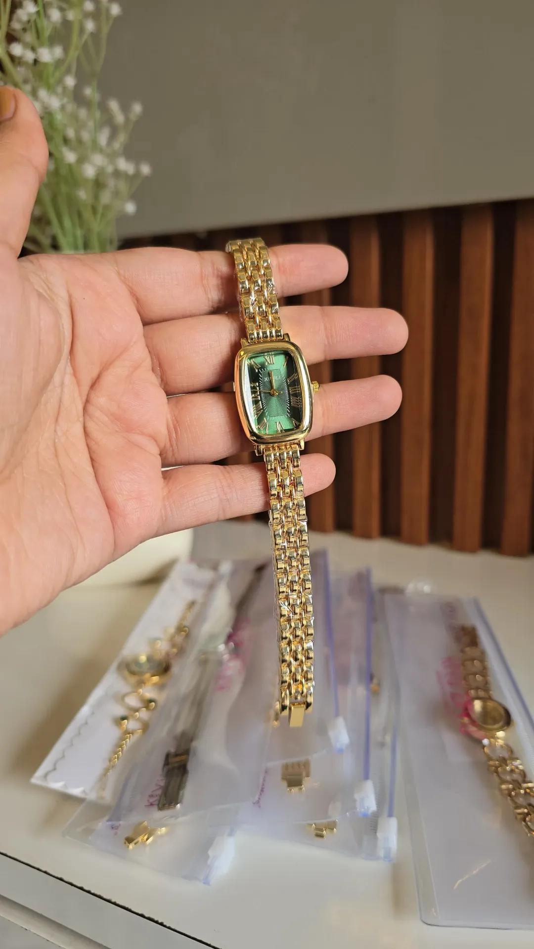 Gold-tone woven mesh bracelet watch with a green rectangular dial and roman numerals