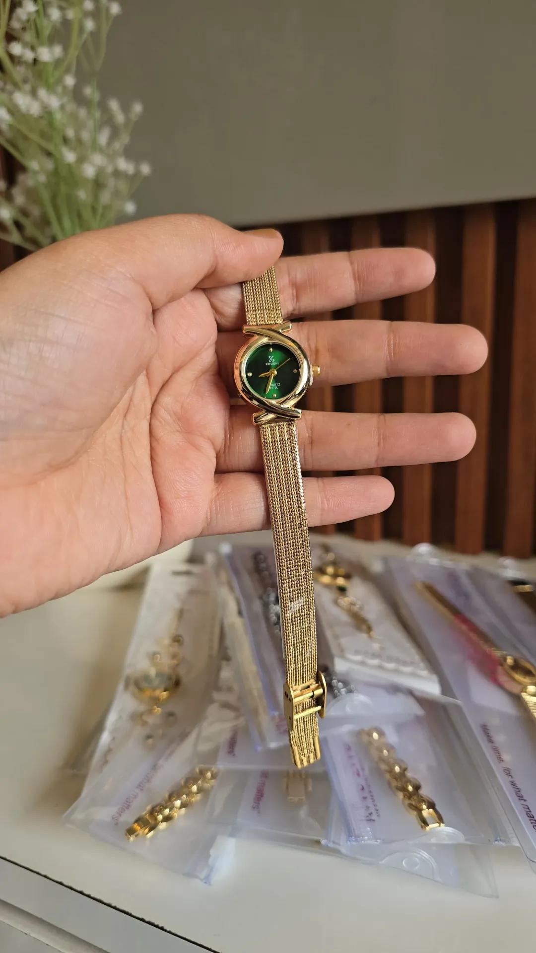 Gold-tone mesh bracelet watch with a green dial and a cross-pattern bezel border
