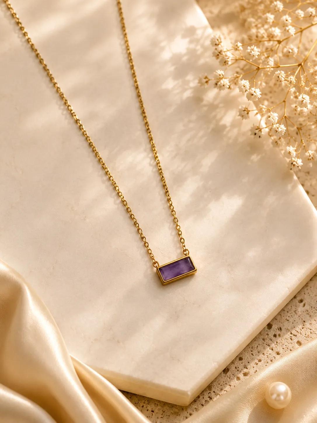 Gold-tone rectangular bar pendant necklace set with an amethyst-purple cubic zirconia stone