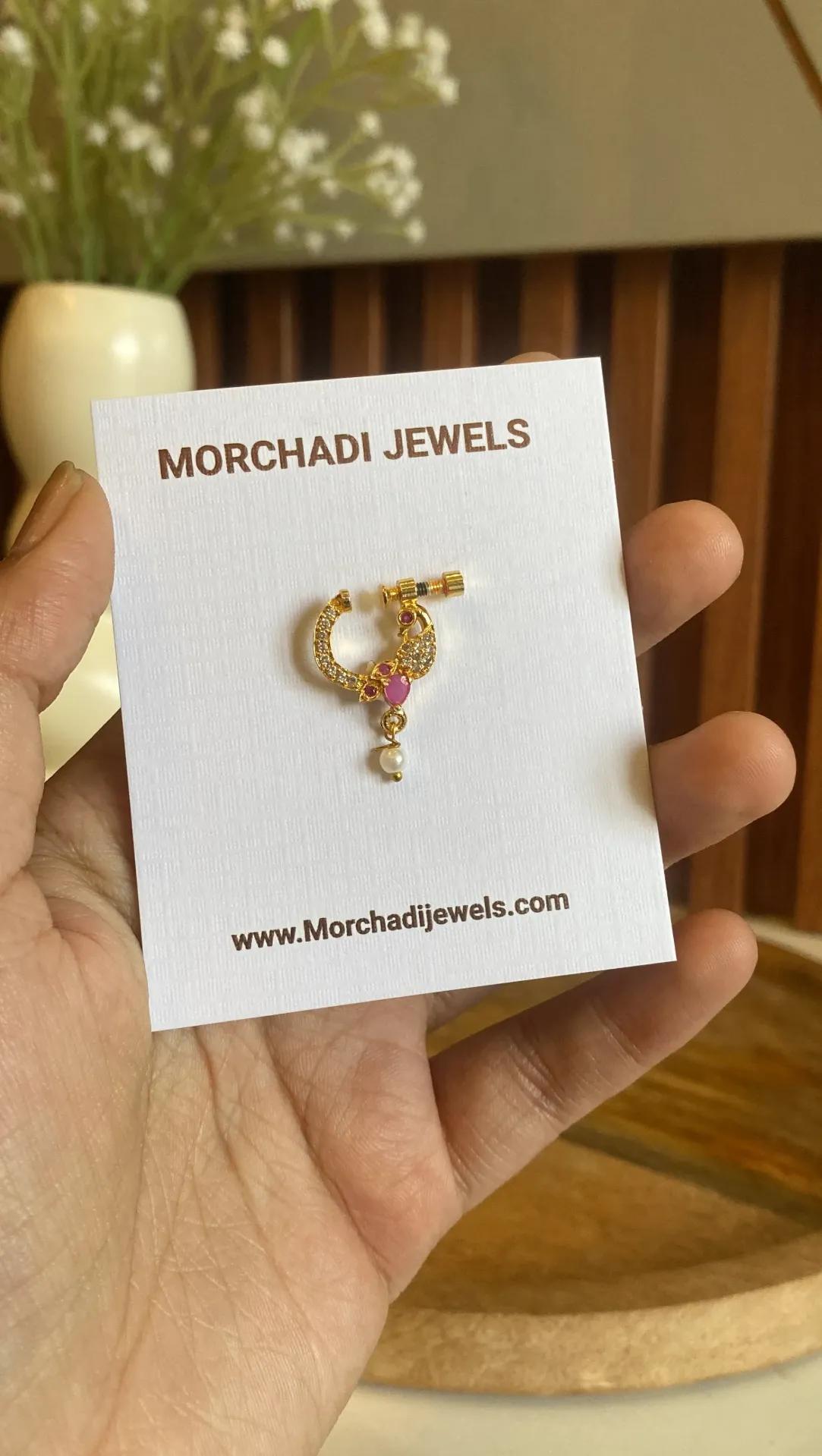Curved peacock nose ring in gold tone with a deep pink-red stone and a pearl-look bead below