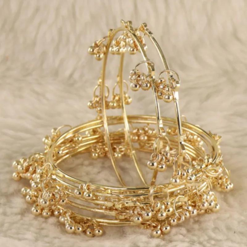 Clusters of small ghungroo bells hung along fine gold-plated bangles