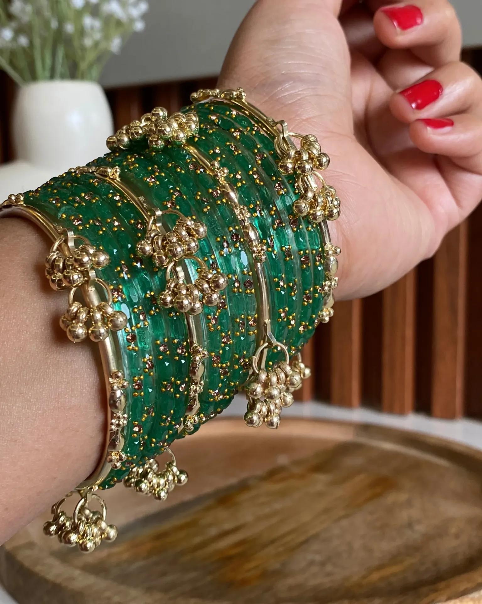 Lacquered green glass bangles with gold and bronze beadwork and hanging ghungroo bells