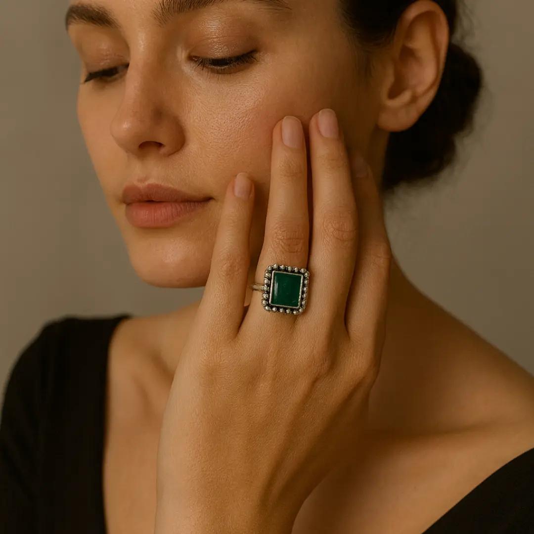 Silver-finish ring with a flat rectangular green stone in a beaded frame
